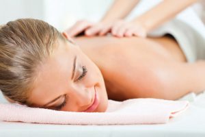Jeune femme ayant un massage du dos au centre de bien-être et beauté Jeune femme ayant un massage du dos au centre de bien-être et beauté